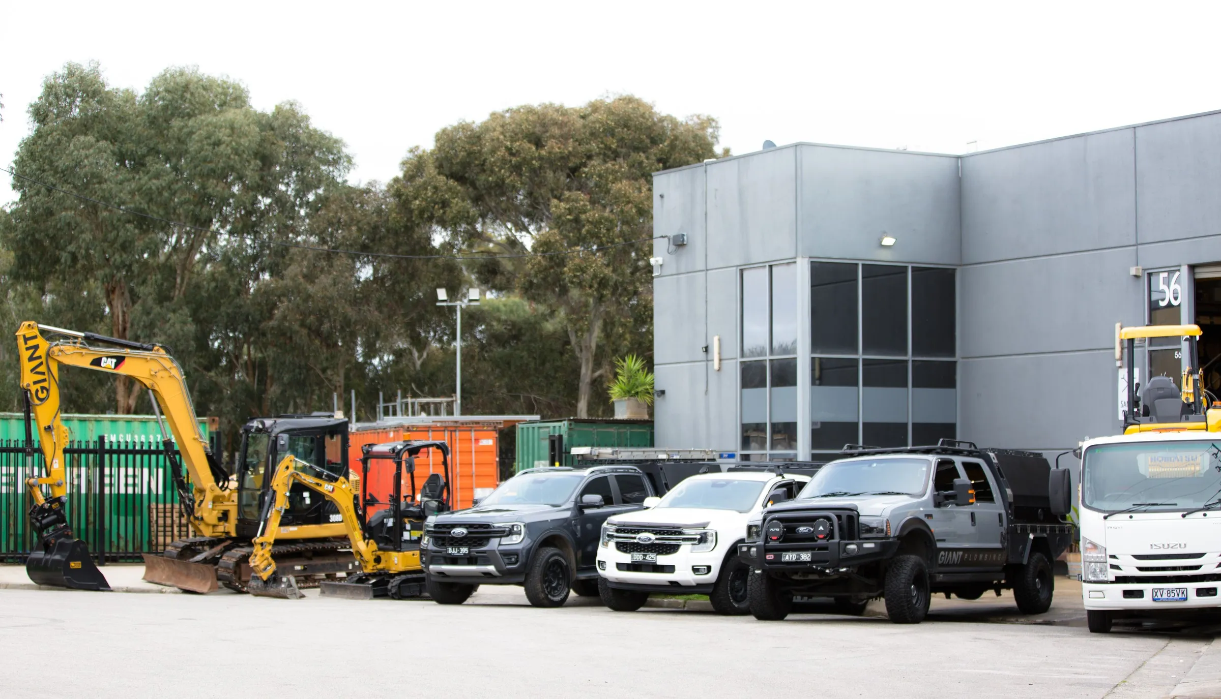 Giant Plumbing's excavators, utes and tip truck lined up at the Coburg North yard