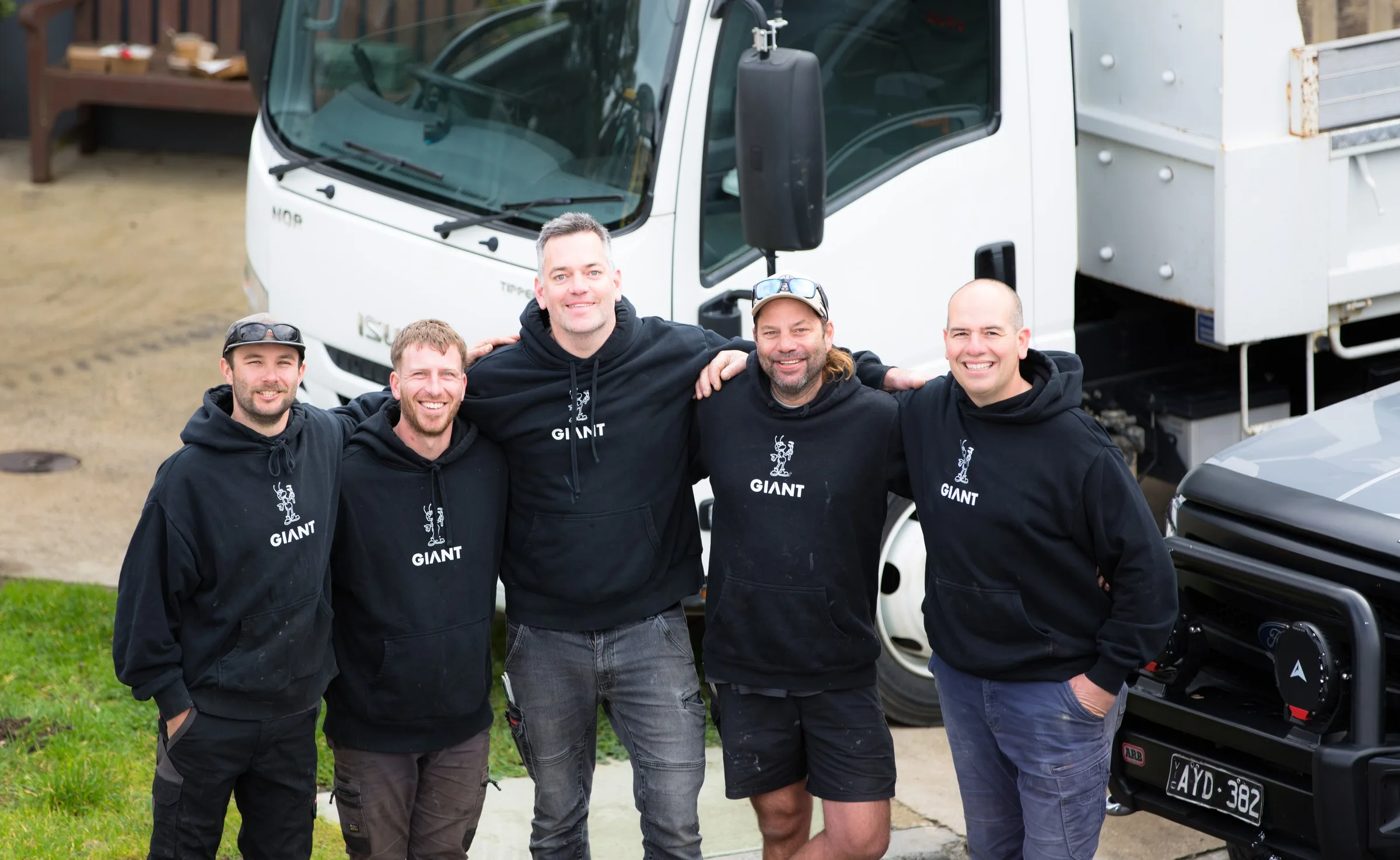 Giant Plumbing team standing together beside the tip truck