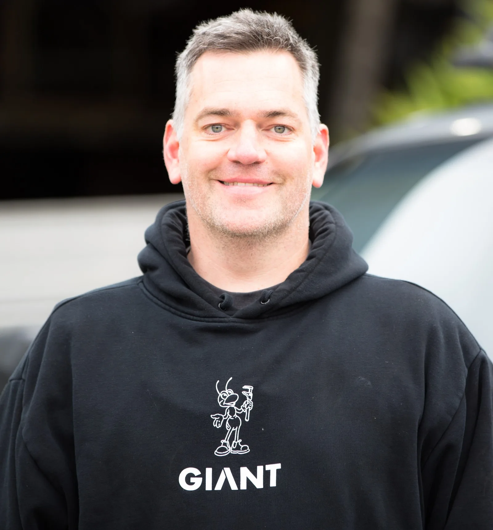 Anthony Richardson, owner and director of Giant Plumbing, smiling in a black Giant hoodie