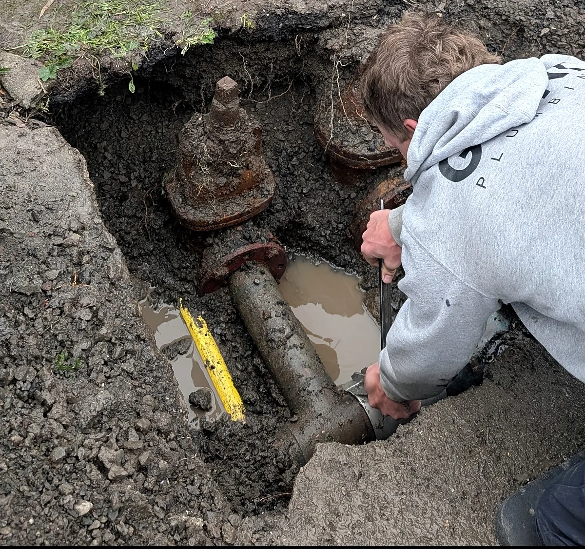 Fire hydrant repair in Melbourne, the old corroded hydrant valve exposed in the dig beside the main
