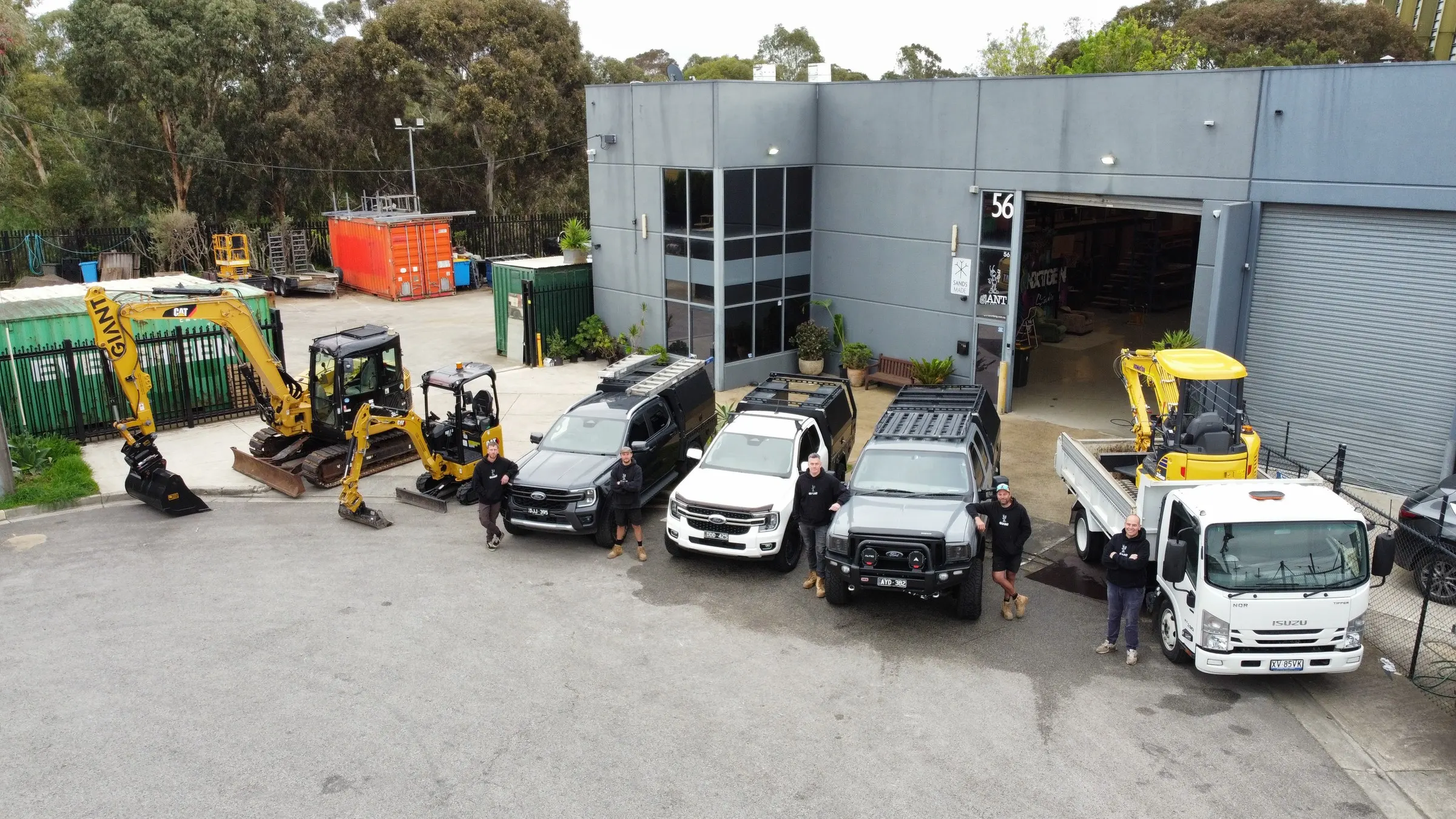 The Giant Plumbing team in front of their three excavators, three utes and tip truck outside the Coburg North workshop, seen from above