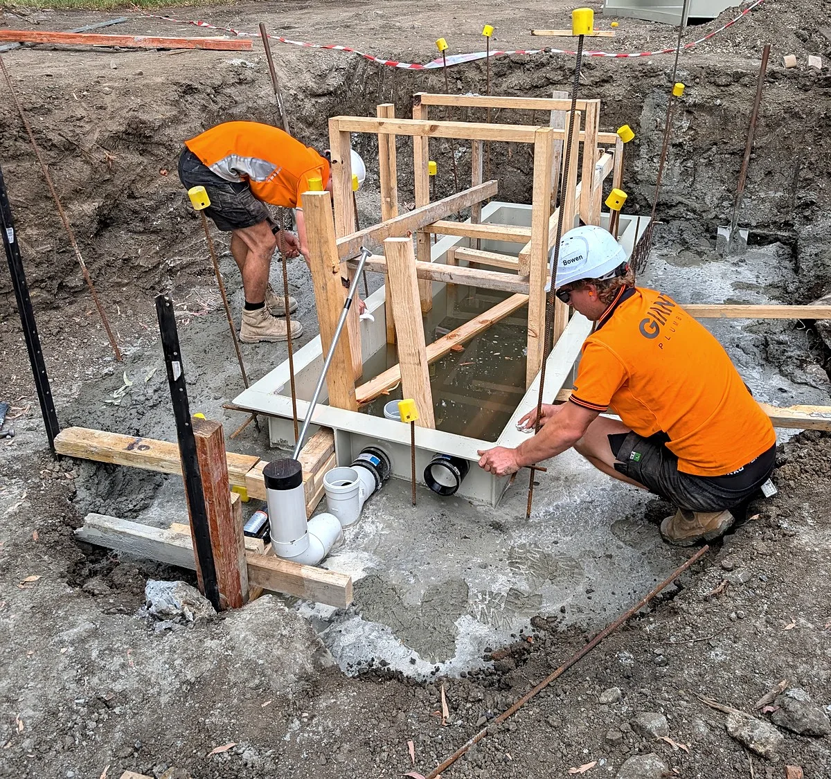 Drainage pit excavation in Melbourne, two Giant Plumbing team members setting up the pit formwork