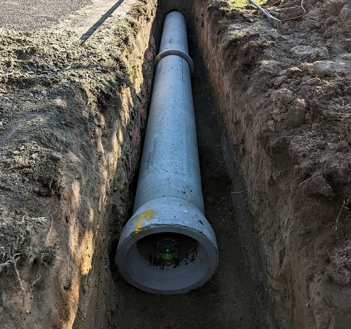 Stormwater drainage excavation in Melbourne, new concrete pipe laid on the floor of an open trench