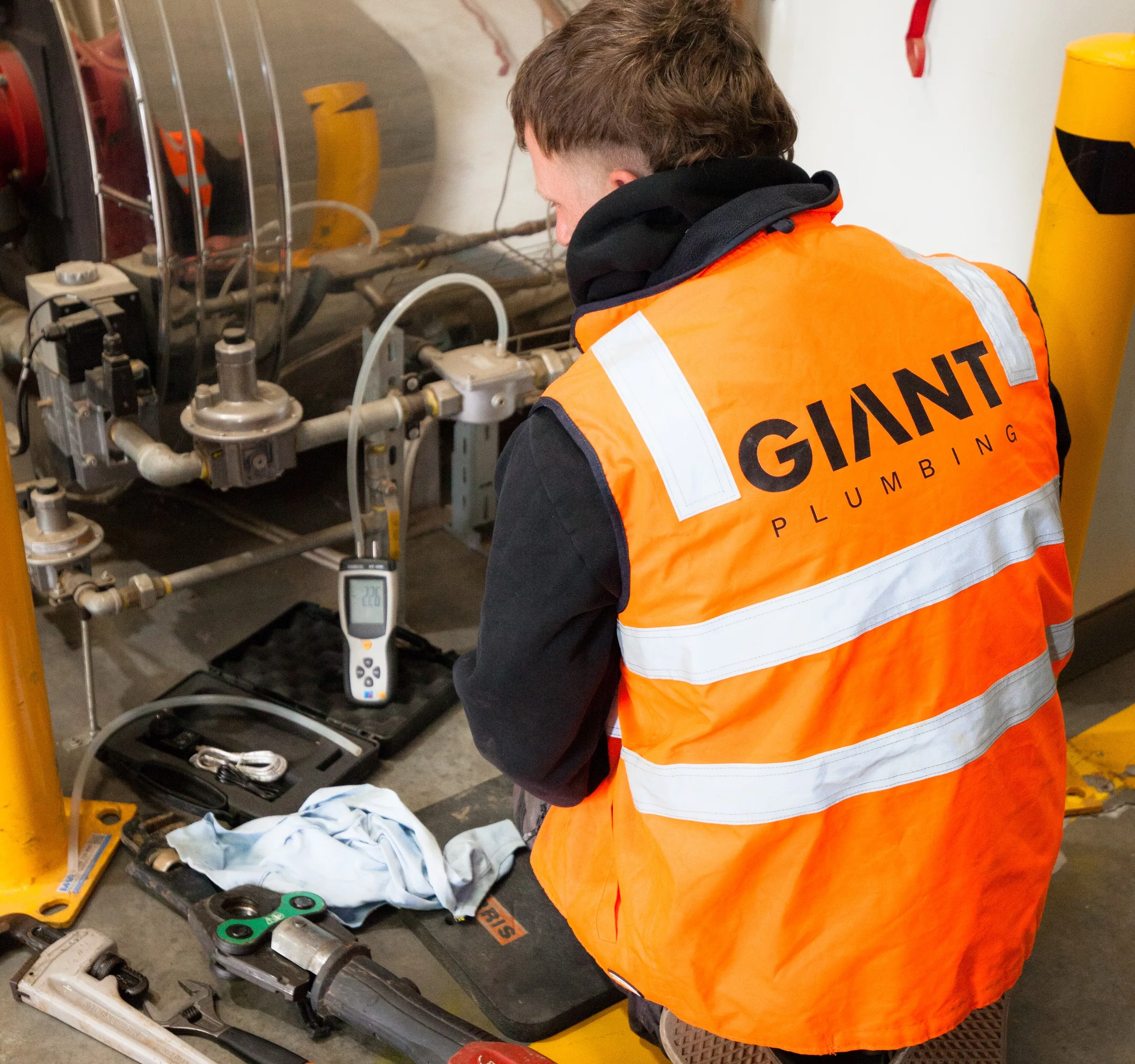 Giant Plumbing team member working on pipework at an industrial plant