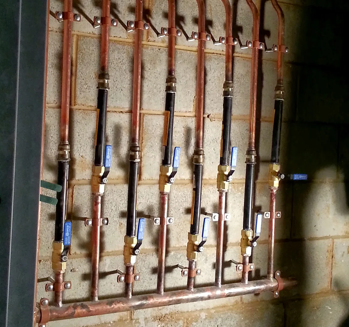 Copper water manifold with isolation valves on a commercial site in Melbourne