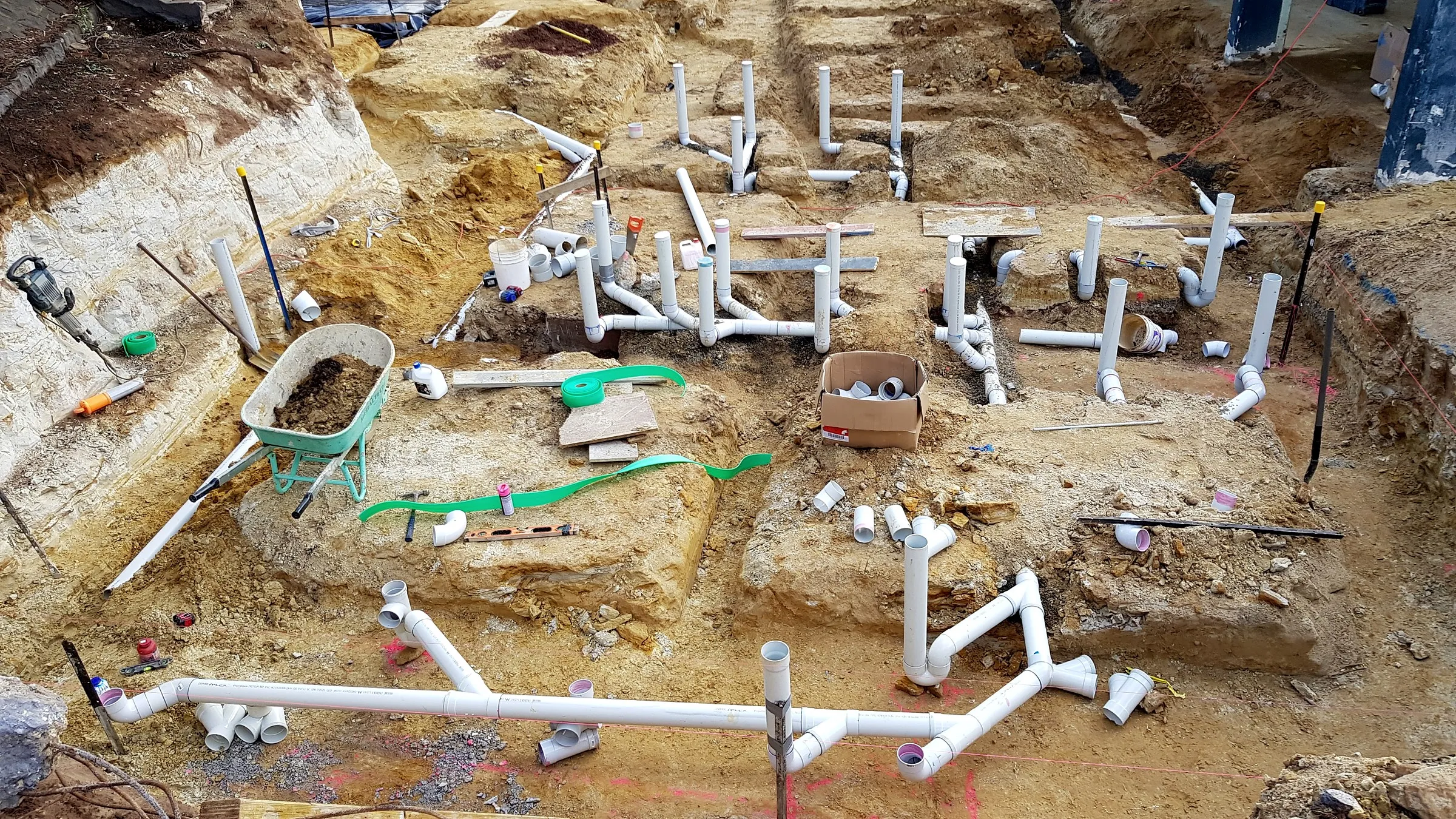 New in-ground PVC drainage laid across an excavated commercial building site